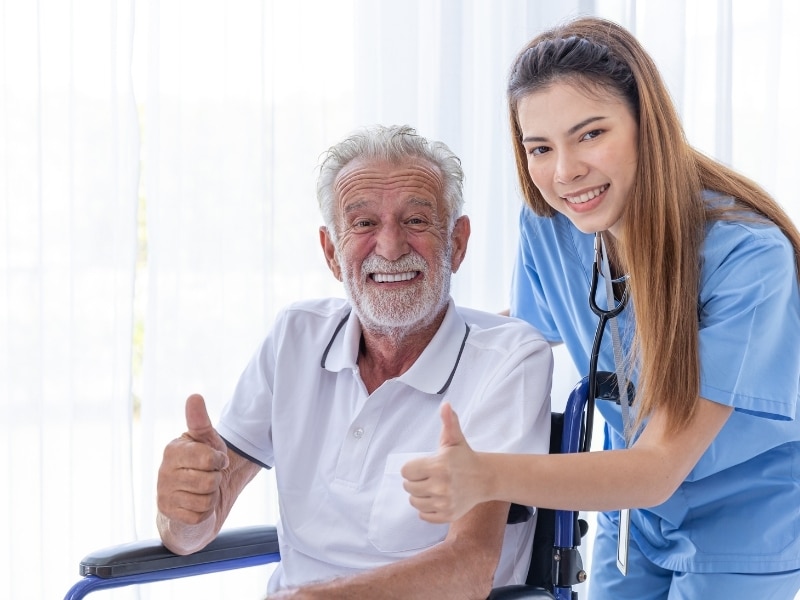 a man in a wheelchair and a professional woman taking a picture happily indicating daily living support