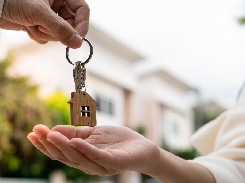 Landlord handing over house keys to a disabled tenant, symbolizing their rights to accessible housing.