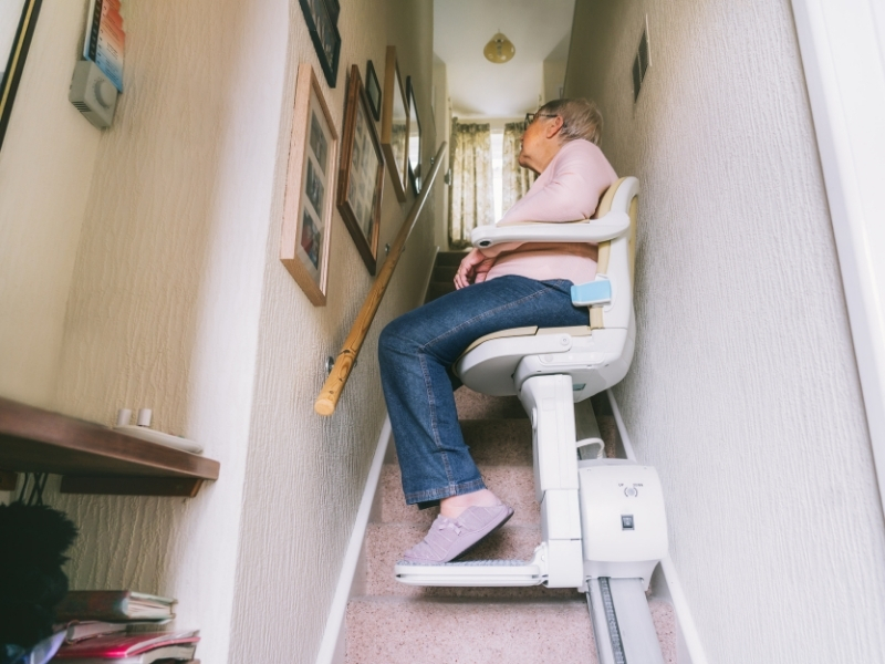 A person using an automatic chair lift, demonstrating enhanced accessibility.