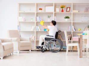 A person with a disability cleans their home, demonstrating independence and disability.