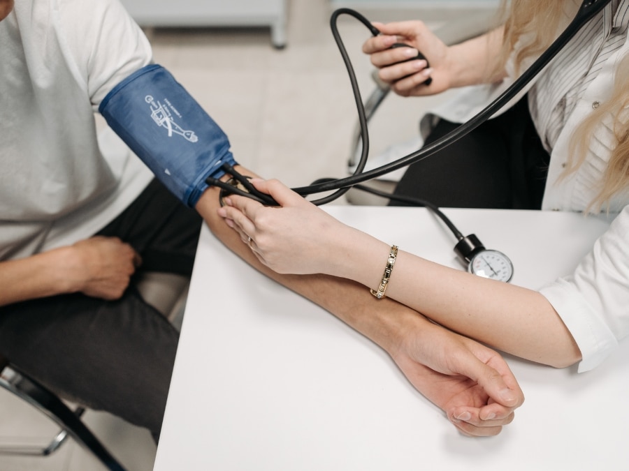 Healthcare provider checking blood pressure of a person with complex needs for personalised care and support.